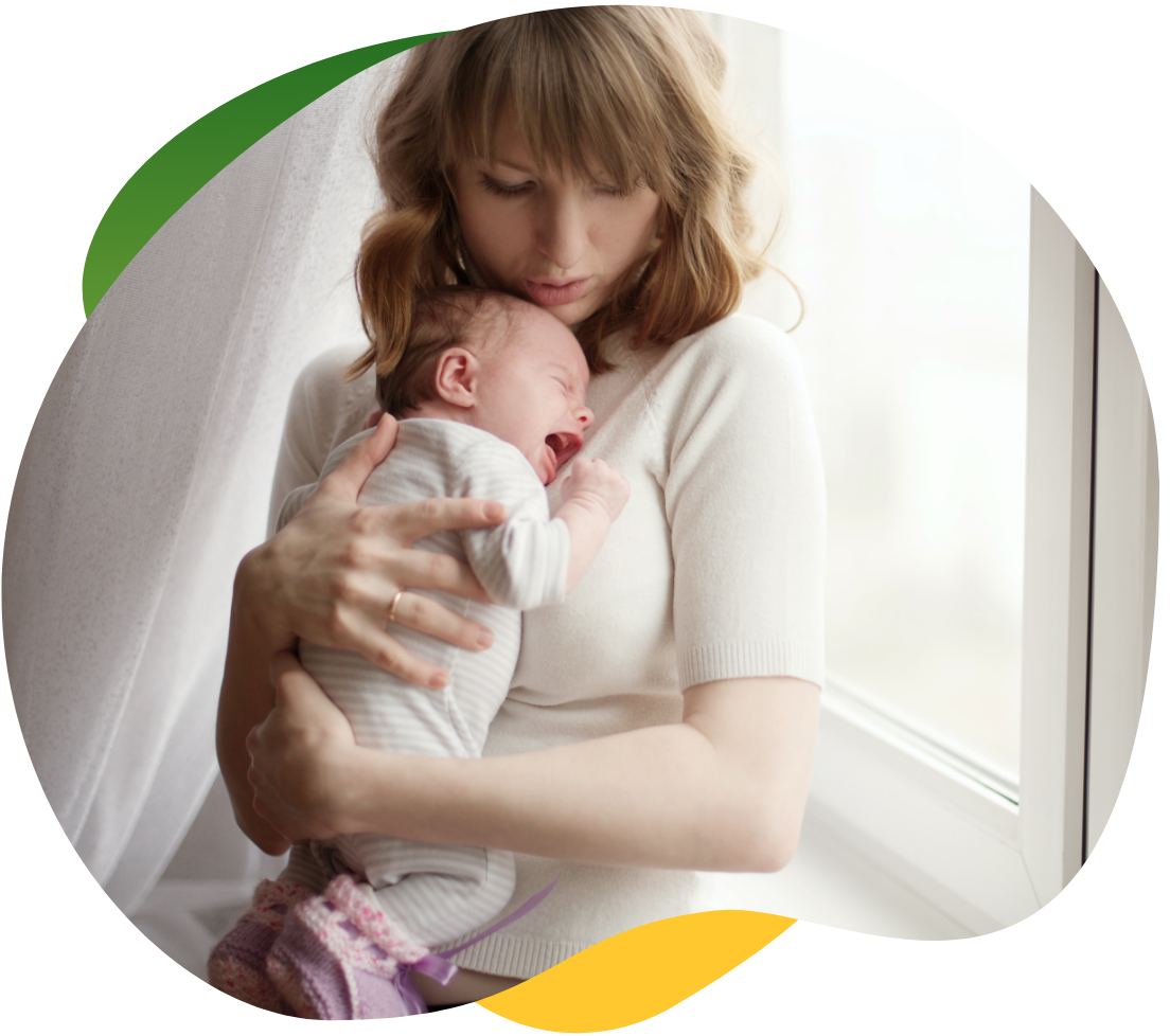 A young mother presses her crying baby to her chest to soothe it from baby colic